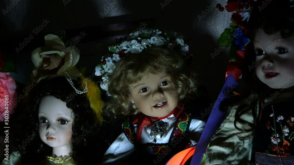 Several dolls on a shelf of an old house in dramatic lighting, looking mysterious and otherworldly inspire fear. Close-up.