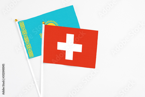 Switzerland and Kazakhstan stick flags on white background. High quality fabric, miniature national flag. Peaceful global concept.White floor for copy space. photo