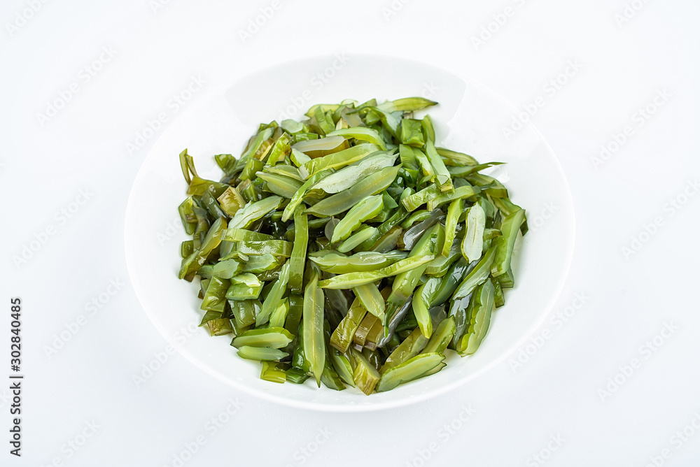 Freshly cut sea cabbage on a saucer on a white background Freshly cut sea cabbage on a saucer on a white background