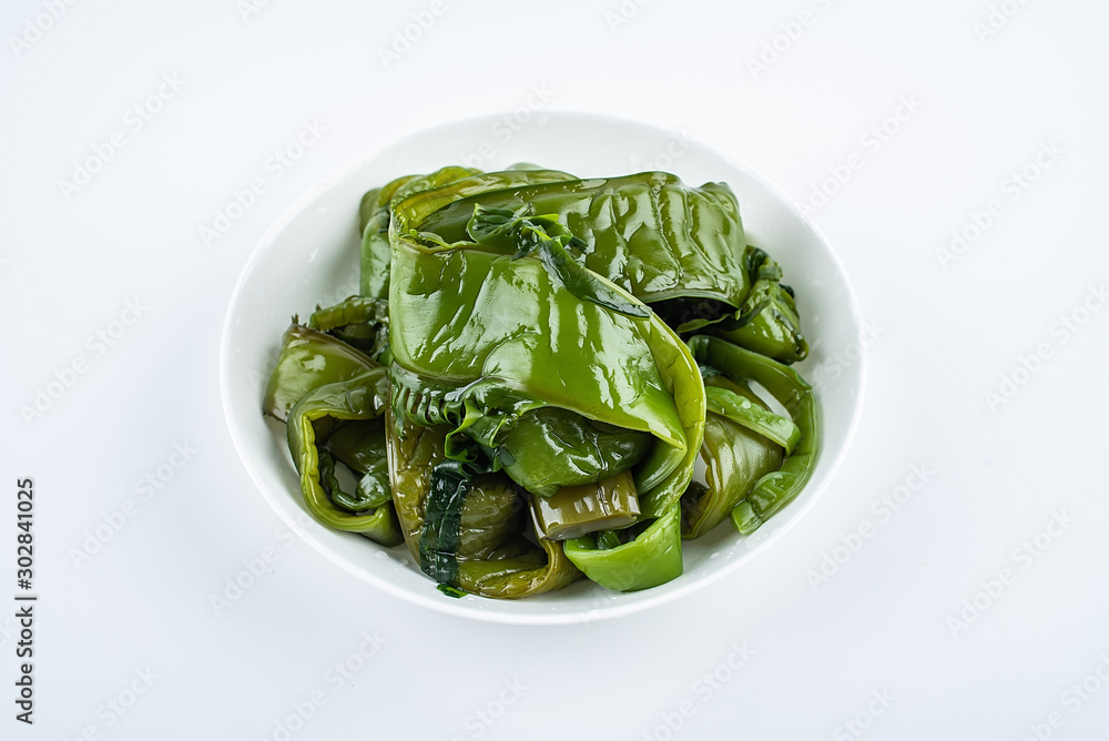 Fresh green sea cabbage on a saucer on a white background Fresh green sea cabbage on a saucer on a white background