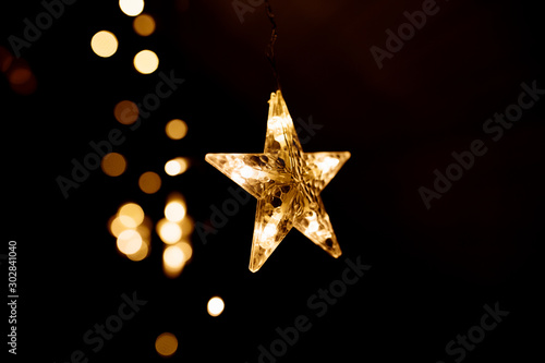 Fotografie Christmas lights on dark background. Star shaped.