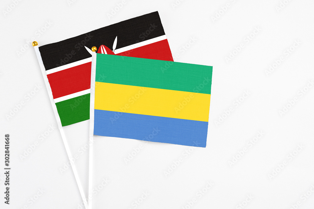 Gabon and Kenya stick flags on white background. High quality fabric, miniature national flag. Peaceful global concept.White floor for copy space. Gabon and Kenya stick flags on white background. High quality fabric, miniature national flag. Peaceful global concept.White floor for copy space.