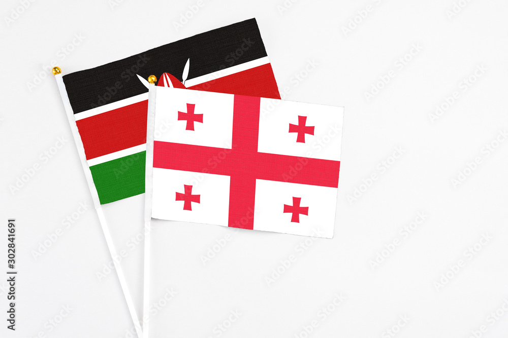 Georgia and Kenya stick flags on white background. High quality fabric, miniature national flag. Peaceful global concept.White floor for copy space.