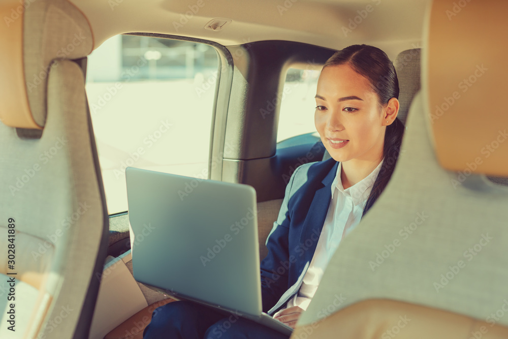 Attentive young female staring at screen of laptop