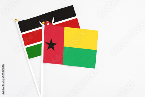 Guinea Bissau and Kenya stick flags on white background. High quality fabric  miniature national flag. Peaceful global concept.White floor for copy space.