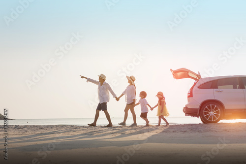 Cheerful family running on the beach in the summer.