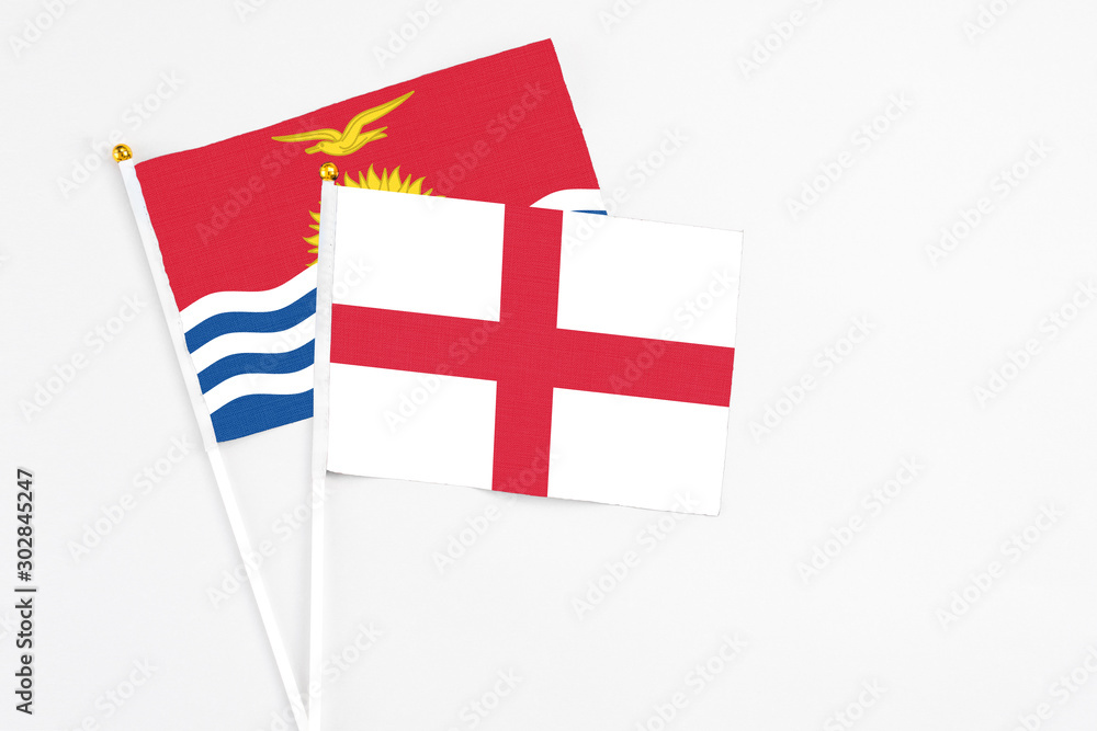 England and Kiribati stick flags on white background. High quality fabric, miniature national flag. Peaceful global concept.White floor for copy space.
