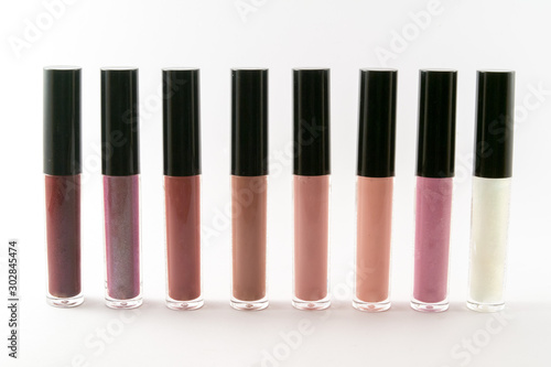Fashion lip gloss collection of different colors and shades isolated on white background.