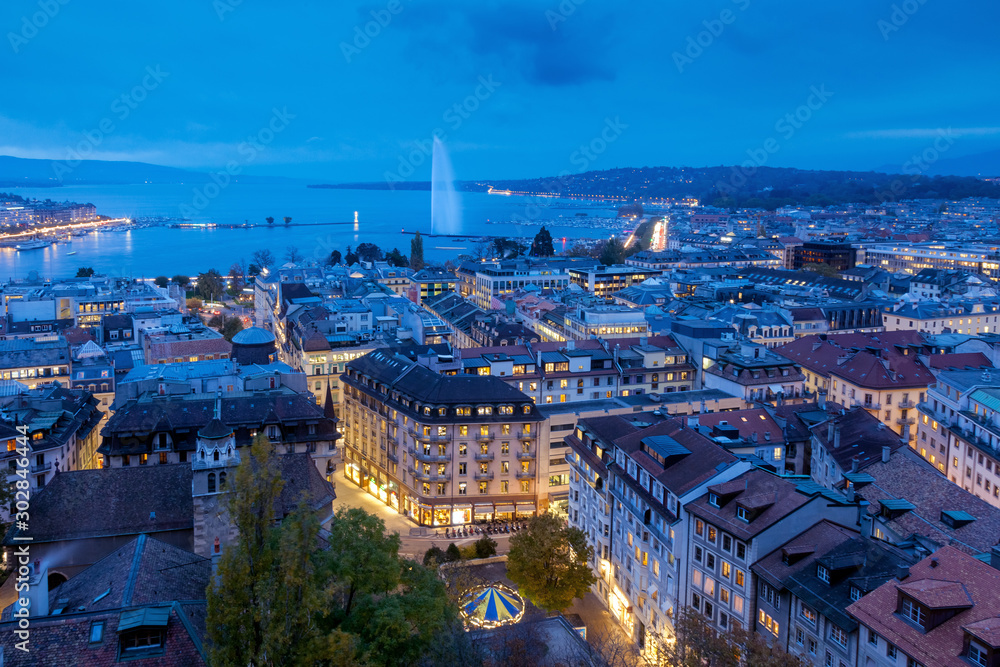 Aerial view of Geneva City center and Jet d'eau by night on World Diabetes Day.  This photo was taken shortly after sunset, at the blue hour, from the top of the tower of St. Peter's Cathedral. 