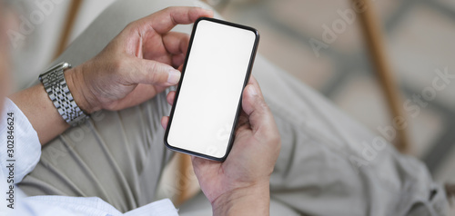 Cropped shot of man holding blank screen smartphone while working the project in outdoor comfortable workplace