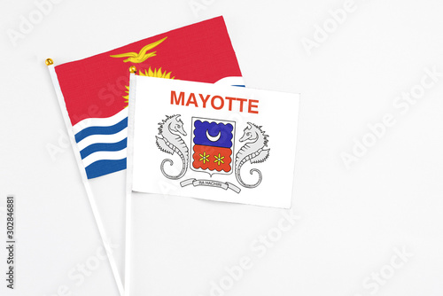 Mayotte and Kiribati stick flags on white background. High quality fabric, miniature national flag. Peaceful global concept.White floor for copy space.