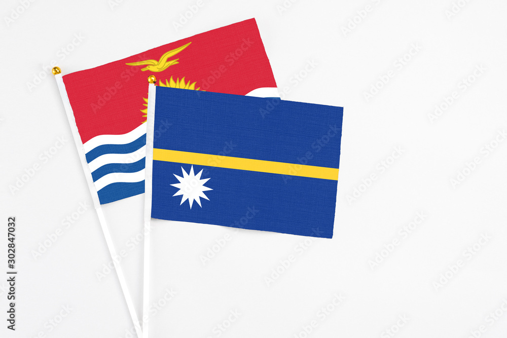 Nauru and Kiribati stick flags on white background. High quality fabric, miniature national flag. Peaceful global concept.White floor for copy space. Nauru and Kiribati stick flags on white background. High quality fabric, miniature national flag. Peaceful global concept.White floor for copy space.