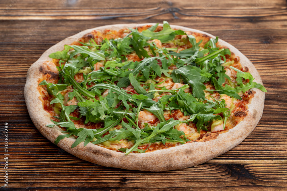 Prawn and cheese pizza with a bunch of fresh arugula Prawn and cheese pizza with a bunch of fresh arugula
