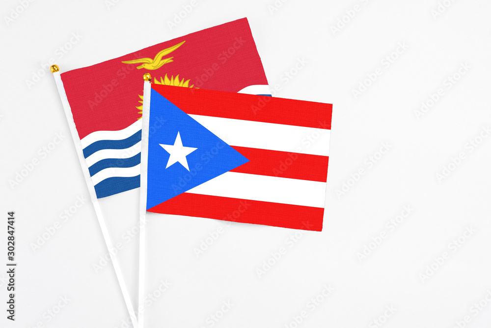 Puerto Rico and Kiribati stick flags on white background. High quality fabric, miniature national flag. Peaceful global concept.White floor for copy space. Puerto Rico and Kiribati stick flags on white background. High quality fabric, miniature national flag. Peaceful global concept.White floor for copy space.