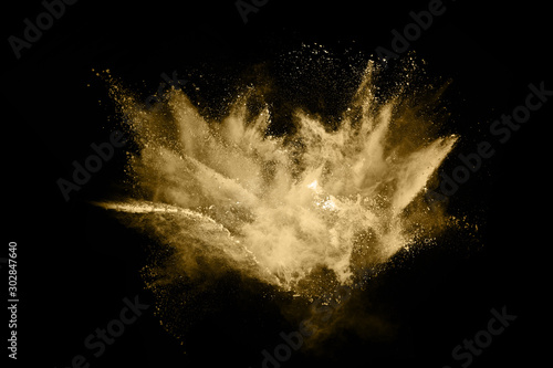 Golden powder explosion on black background. 