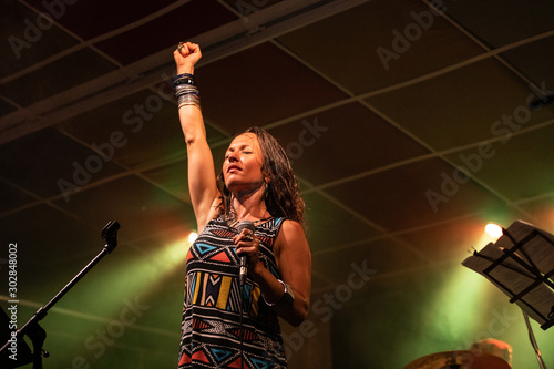 Cuadro en lienzo a female musician is viewed from a low angle as she sings and performs with one