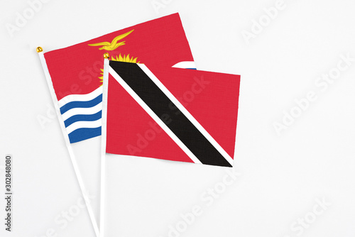 Trinidad And Tobago and Kiribati stick flags on white background. High quality fabric, miniature national flag. Peaceful global concept.White floor for copy space.