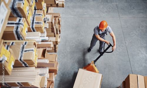 Top view of male worker in warehouse with pallet truck