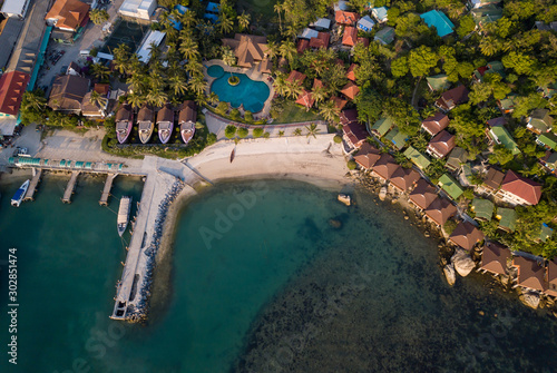 Aerial: Above beachfront resort with sea view on beautiful tropical island koh Phangan, Haad Rin area 