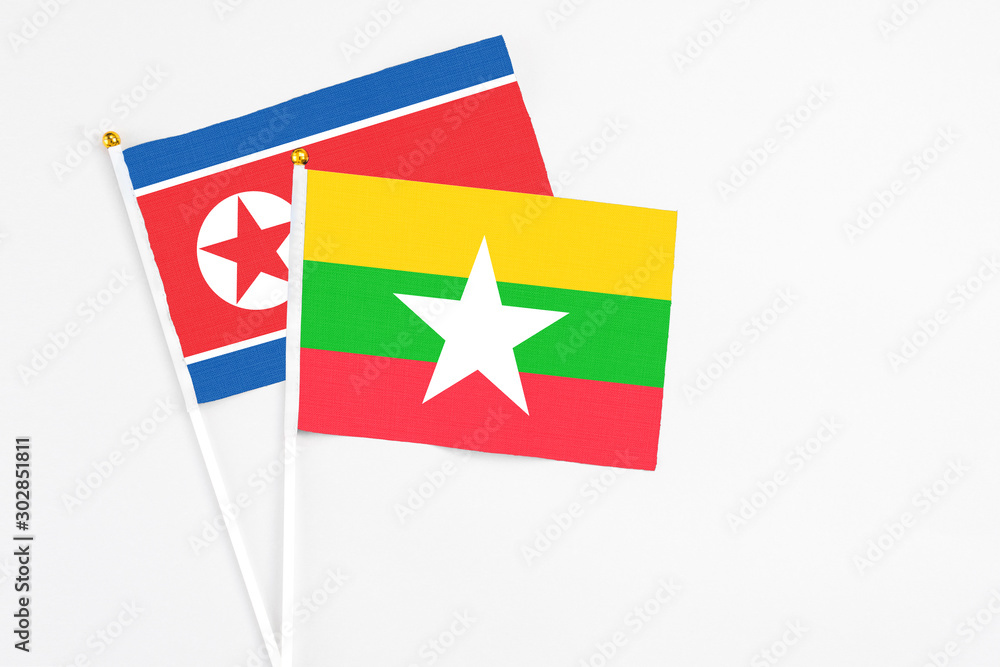 Myanmar and North Korea stick flags on white background. High quality fabric, miniature national flag. Peaceful global concept.White floor for copy space. Myanmar and North Korea stick flags on white background. High quality fabric, miniature national flag. Peaceful global concept.White floor for copy space.