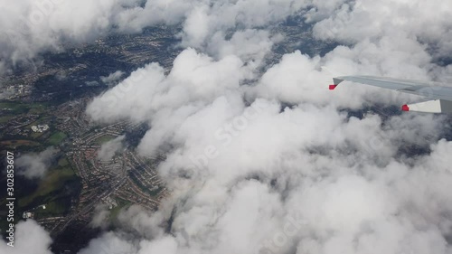 Wing of an airplane turning above clouds