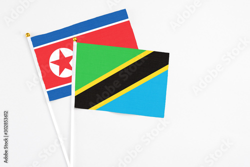 Free Download Tanzania and North Korea stick flags on white background. High quality fabric, miniature national flag. Peaceful global concept.White floor for copy space. - GFXLoad