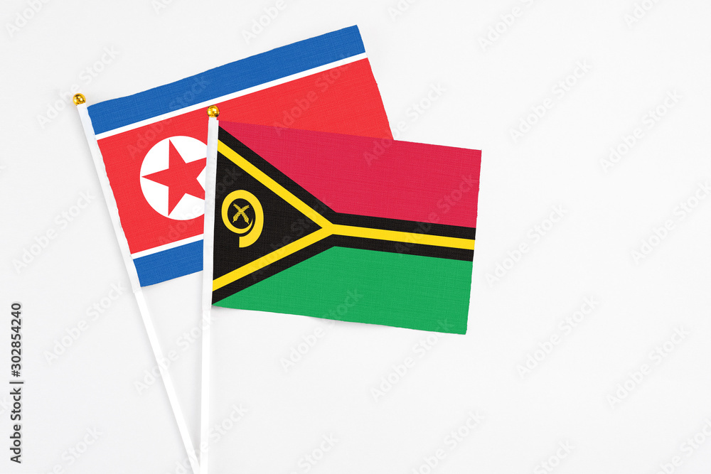 Vanuatu and North Korea stick flags on white background. High quality fabric, miniature national flag. Peaceful global concept.White floor for copy space.
