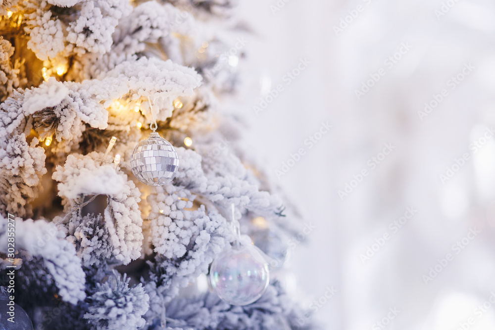 Christmas tree branch with decorations New Year gift ball snowflakes close up, silver white color Christmas tree branch with decorations New Year gift ball snowflakes close up, silver white color