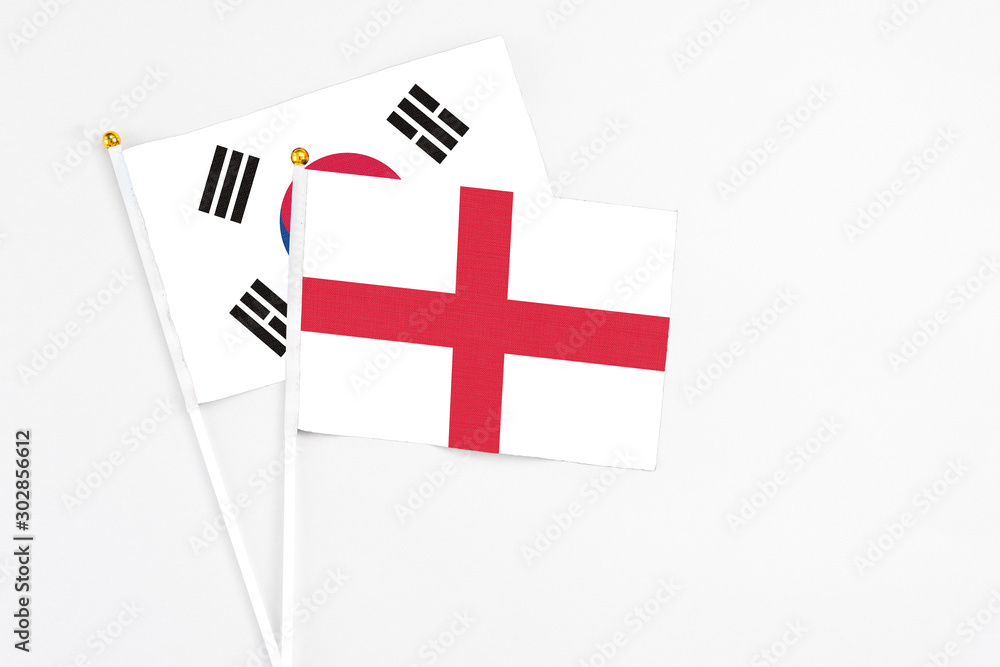 England and South Korea stick flags on white background. High quality fabric, miniature national flag. Peaceful global concept.White floor for copy space.
