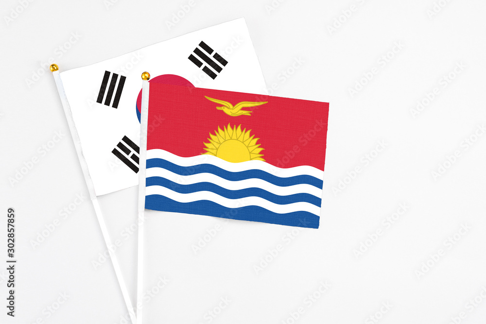 Kiribati and South Korea stick flags on white background. High quality fabric, miniature national flag. Peaceful global concept.White floor for copy space.
