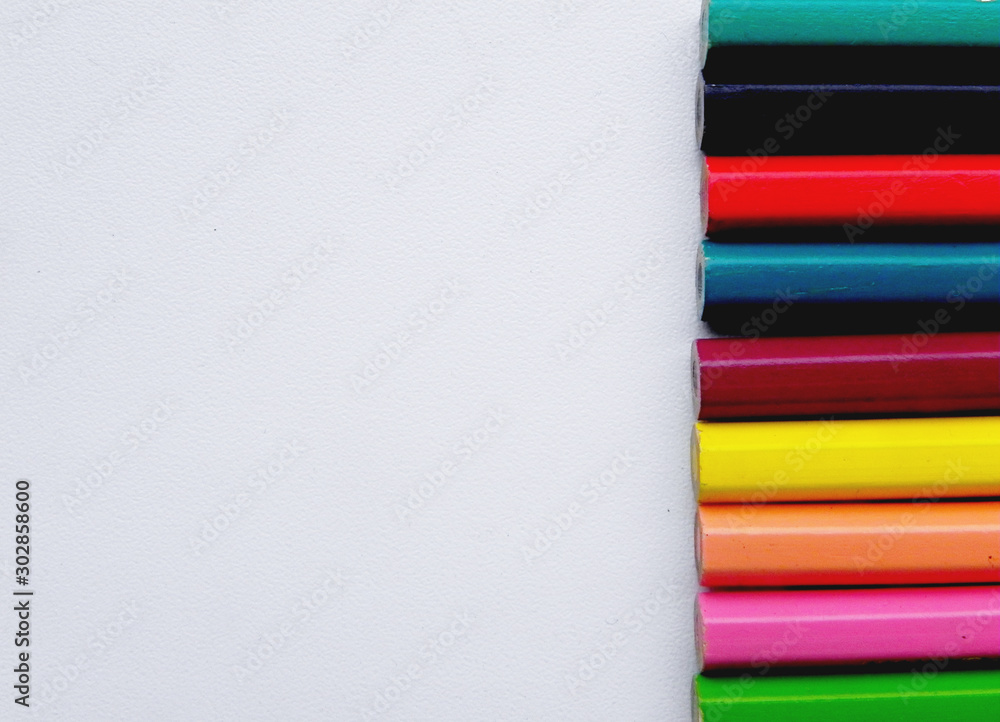 children's colored pencils on a white background, located on the side, with space for text children's colored pencils on a white background, located on the side, with space for text