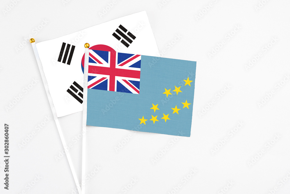 Fototapeta premium Tuvalu and South Korea stick flags on white background. High quality fabric, miniature national flag. Peaceful global concept.White floor for copy space.