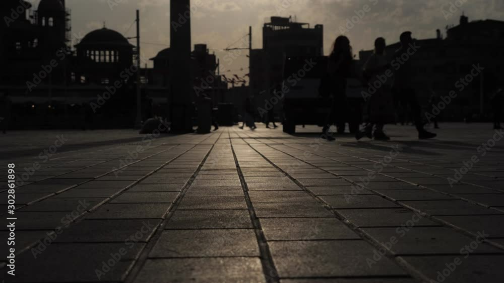 people silhouettes walk along muslim city downtown against urban buildings at darkness with lit asphalt pavement people silhouettes walk along muslim city downtown against urban buildings at darkness with lit asphalt pavement