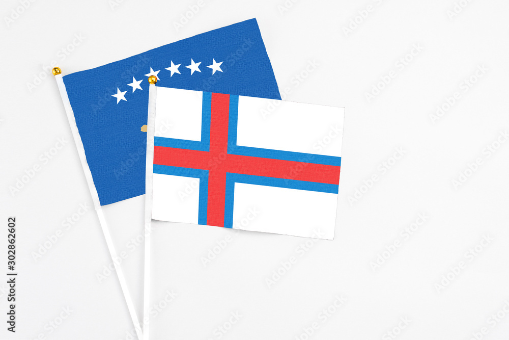 Faroe Islands and Kosovo stick flags on white background. High quality fabric, miniature national flag. Peaceful global concept.White floor for copy space.