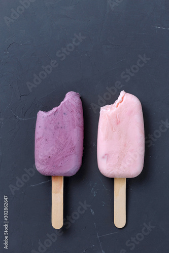 Bitten popsicles yogurt fruit ice cream on a gray background. Copy space. Diet concept.
