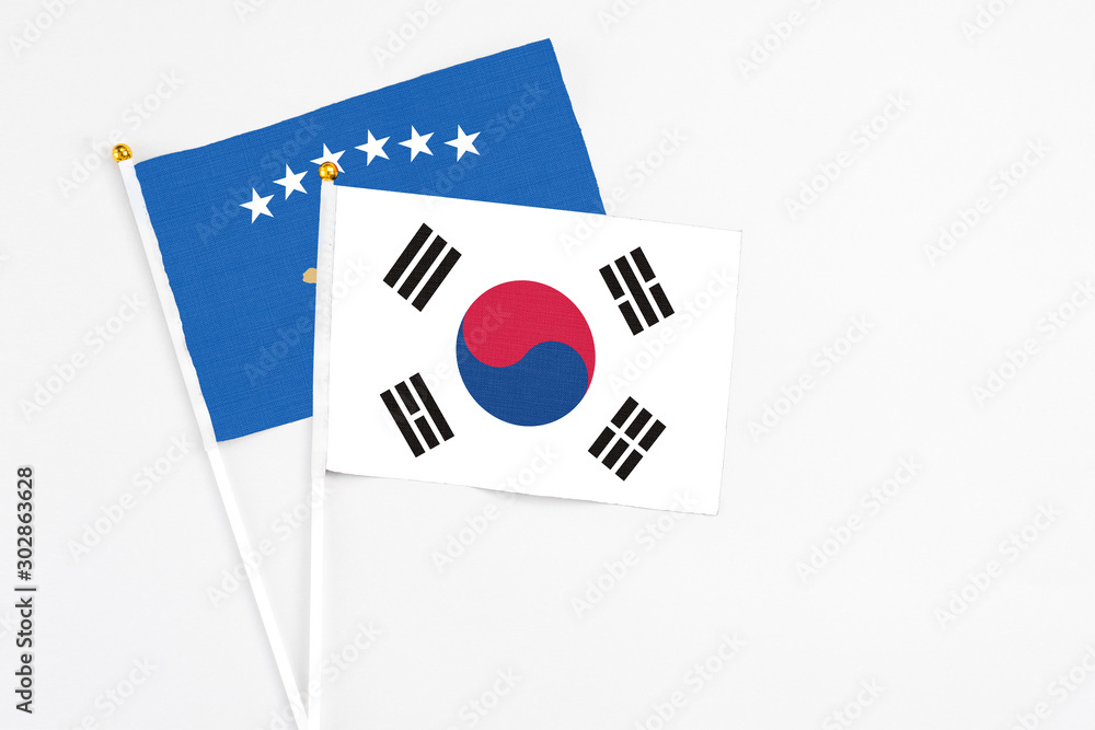 South Korea and Kosovo stick flags on white background. High quality fabric, miniature national flag. Peaceful global concept.White floor for copy space.