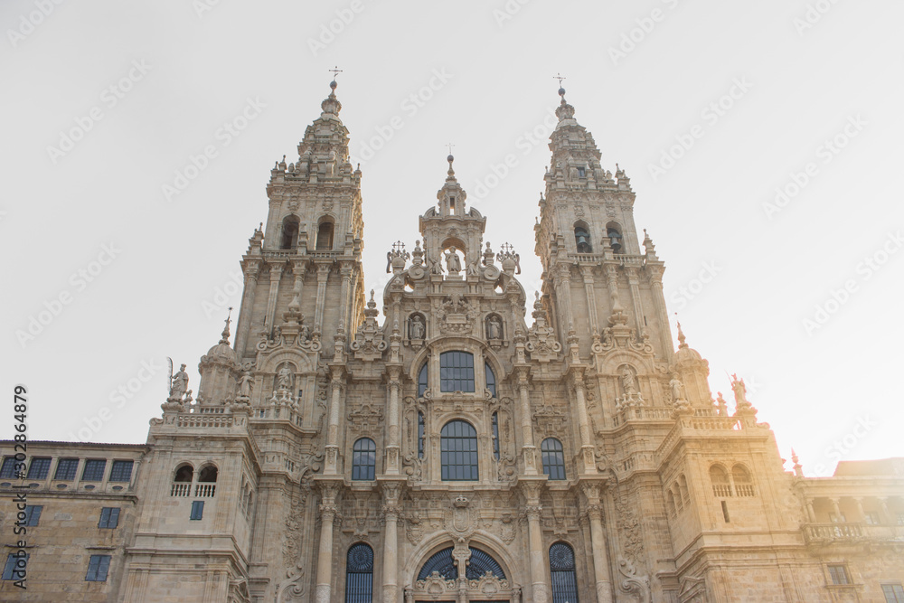 Santiago de Compostela, Spain - 10/18/2018: Cathedral of Saint James with sun light in Santiago de Compostela, Spain. Famous cathedral on Camino de Santiago. Pilgrimage concept. 
