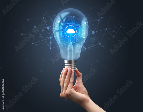 Hand holding light bulb on dark background. Networking idea concept