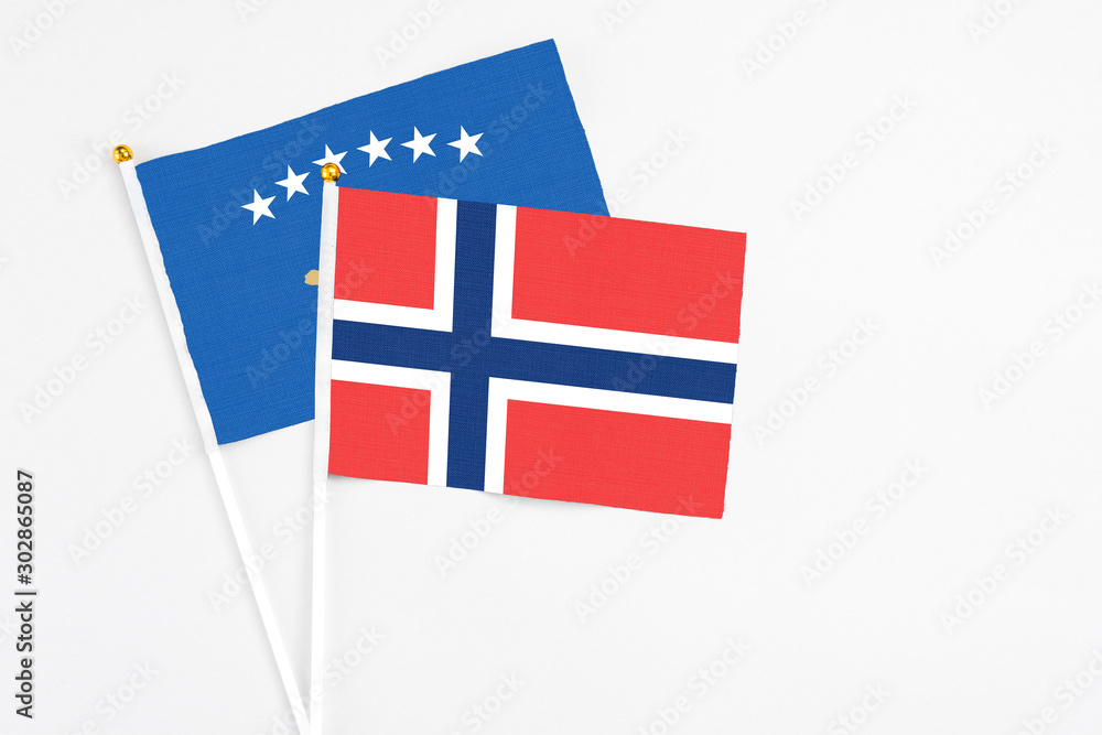 Norway and Kosovo stick flags on white background. High quality fabric, miniature national flag. Peaceful global concept.White floor for copy space.