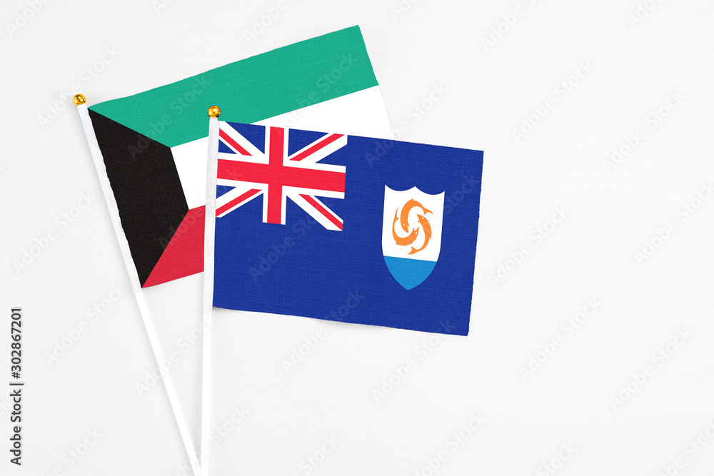 Fototapeta premium Anguilla and Kuwait stick flags on white background. High quality fabric, miniature national flag. Peaceful global concept.White floor for copy space.