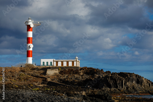 Punta Abona lighthouse. Landscape overlooking the ocean. Sunset. The water is shiny. Tenerife Island, Spain photo