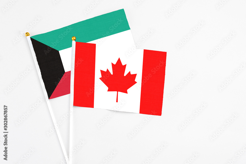 Canada and Kuwait stick flags on white background. High quality fabric, miniature national flag. Peaceful global concept.White floor for copy space. Canada and Kuwait stick flags on white background. High quality fabric, miniature national flag. Peaceful global concept.White floor for copy space.