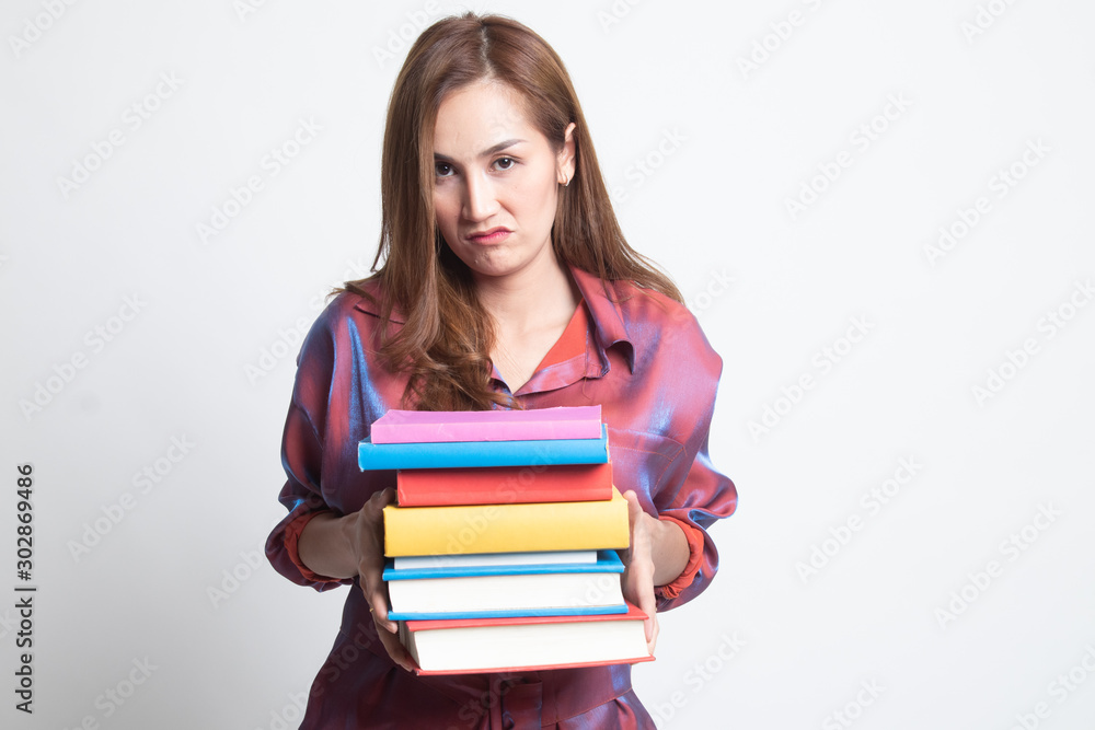 Unhappy young Asian woman studying with may books. Unhappy young Asian woman studying with may books.