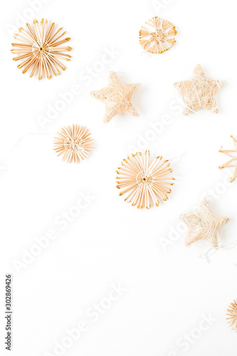 Straw decorations on white background. Flat lay, top view Christmas / New Year minimal composition.