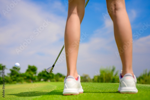 Pitching wedge taking golf ball away from edge of the green to destination hole on the green, final destination for the winner of the woman golfer