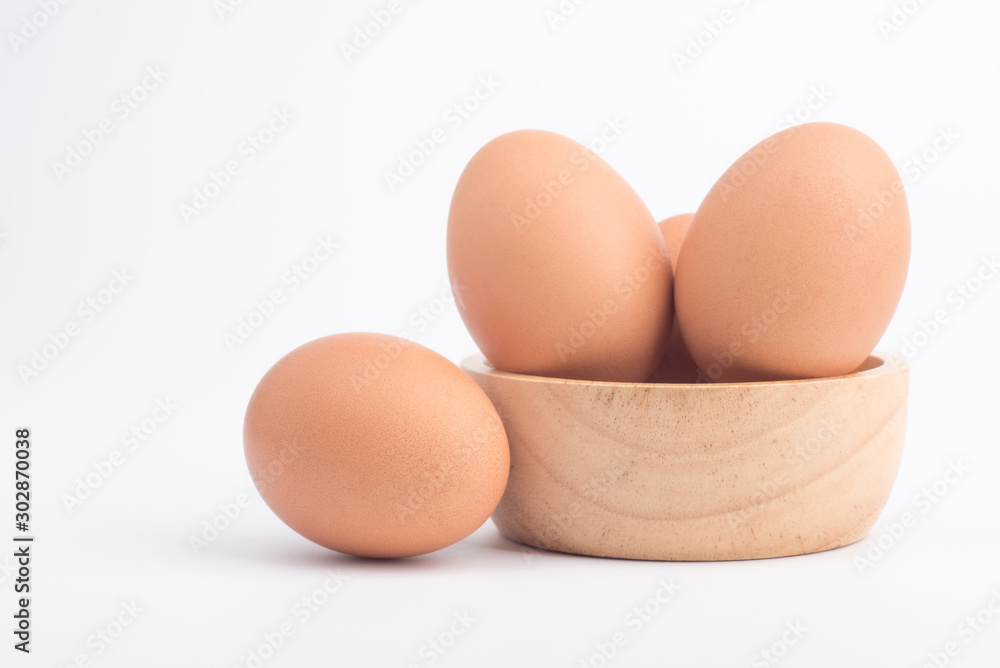 Organic fresh chicken eggs in a brown wooden bowl on a white background Organic fresh chicken eggs in a brown wooden bowl on a white background