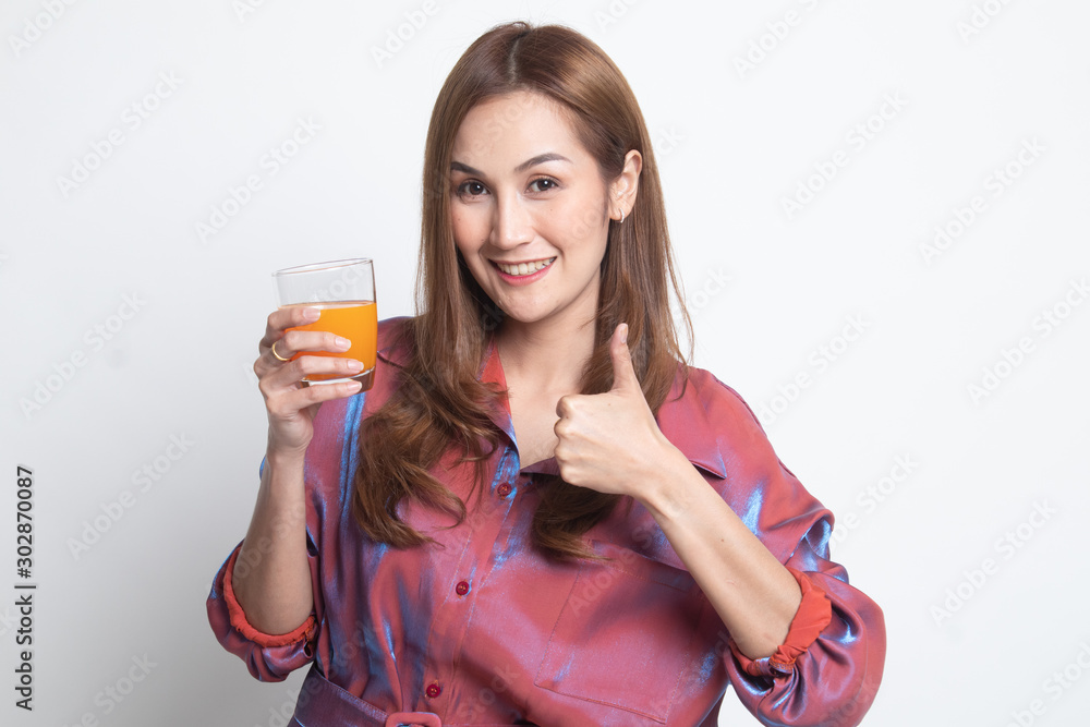 Young Asian woman thumbs up drink orange juice. Young Asian woman thumbs up drink orange juice.