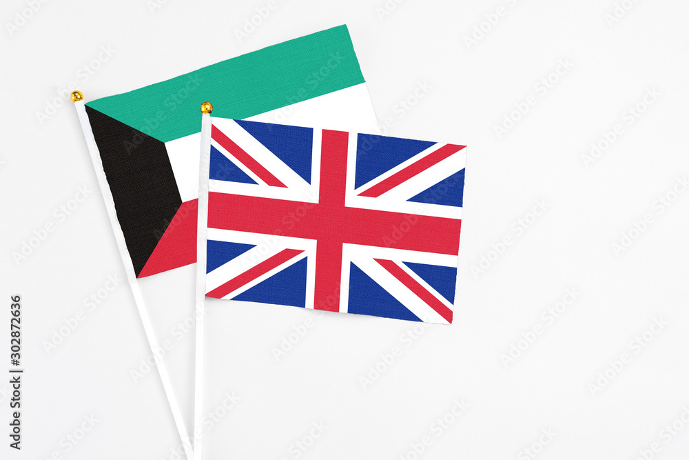 United Kingdom and Kuwait stick flags on white background. High quality fabric, miniature national flag. Peaceful global concept.White floor for copy space. United Kingdom and Kuwait stick flags on white background. High quality fabric, miniature national flag. Peaceful global concept.White floor for copy space.