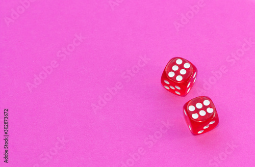 Gambling dices on a pink background.