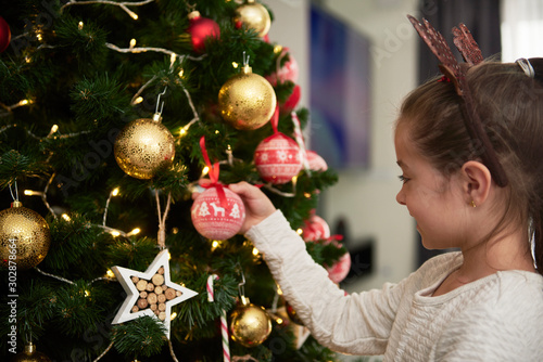 Child decorating the Christmas tree photo